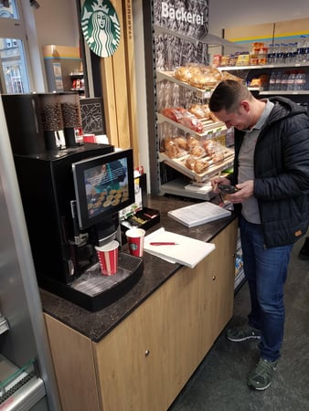 Techniker füllt Rapport bei einer Kaffeemaschine aus